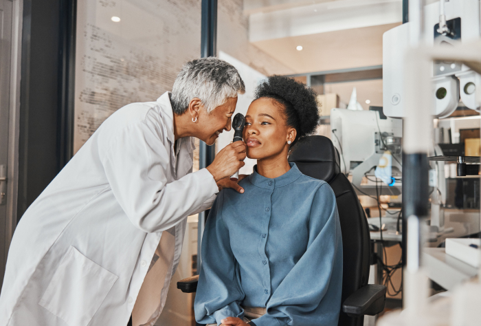 Healthcare professional inspecting the eyes of a patient